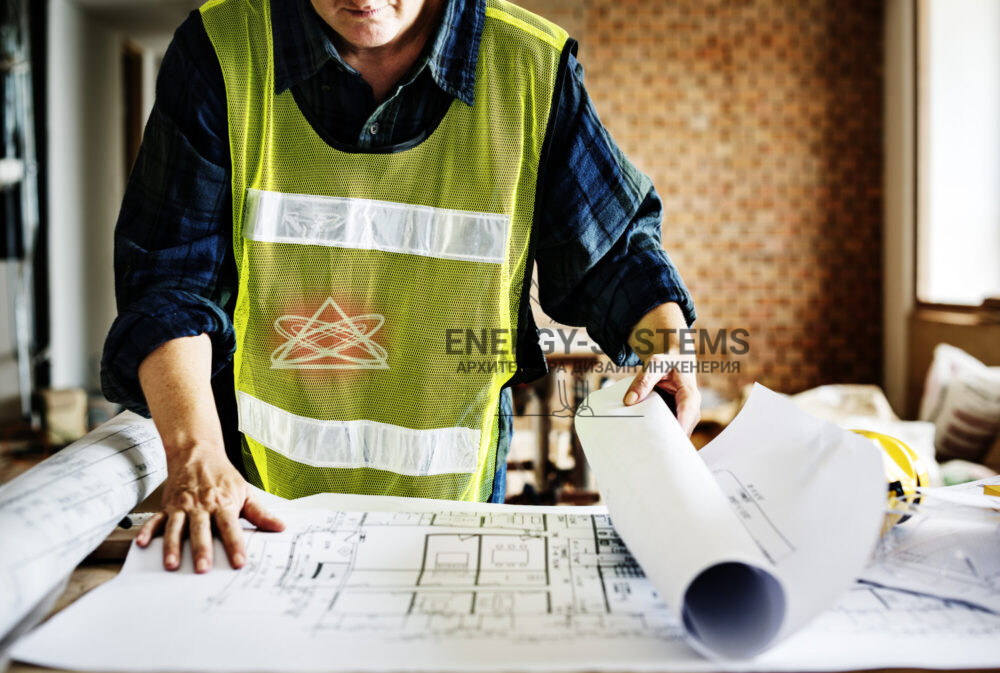 работник в желтой жилетке разворачивает проект