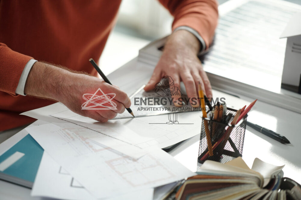 мужчина за столом чертит под линейку в проекте