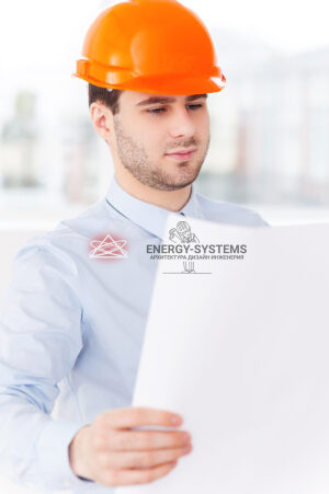 молодой парень в каске осматривает проектную документацию