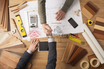 архитектор и заказчик пожимают друг другу руки над проектом