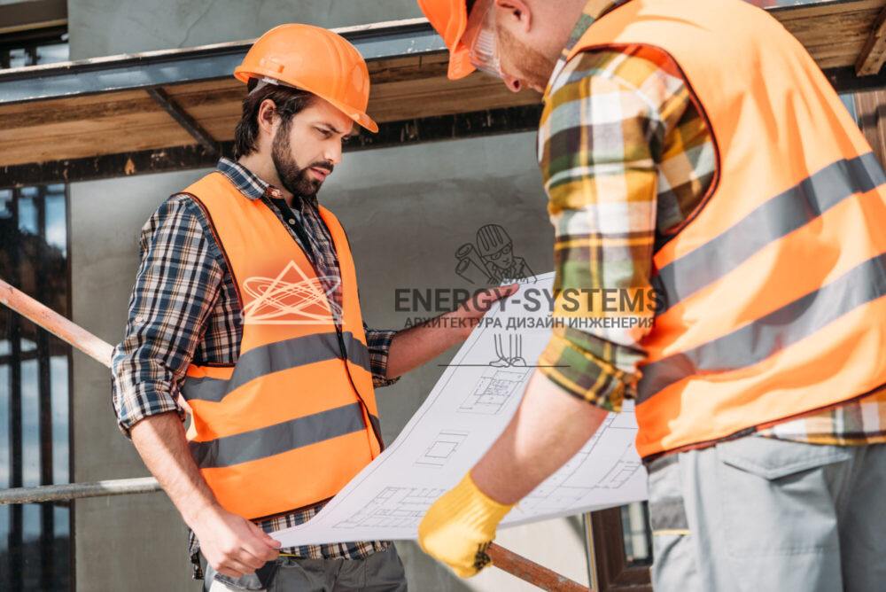 работники рассматривают проект на строительной площадке