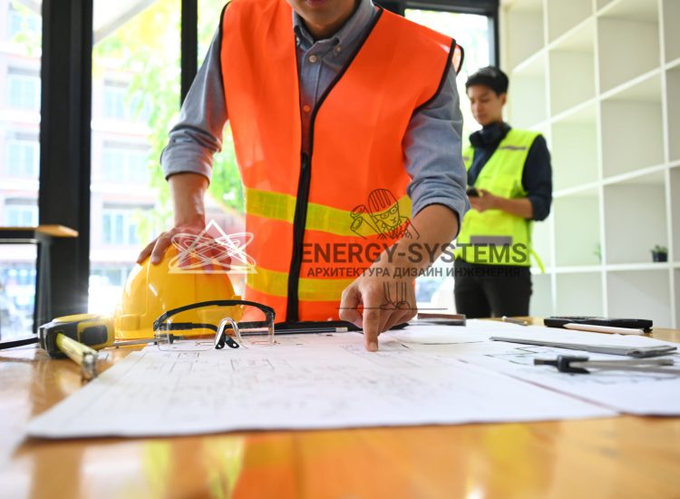 рабочий с каской указывает на проект