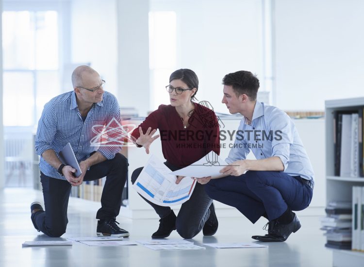 Коллеги работают над проектом: чертежи инженерного проектирования