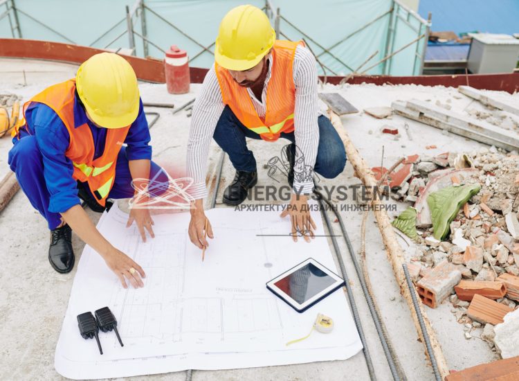 инженеры обсуждают проектный план на стройплощадке