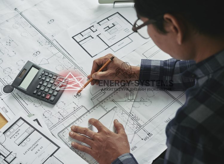 мужчина чертит проект с калькулятором и линейкой