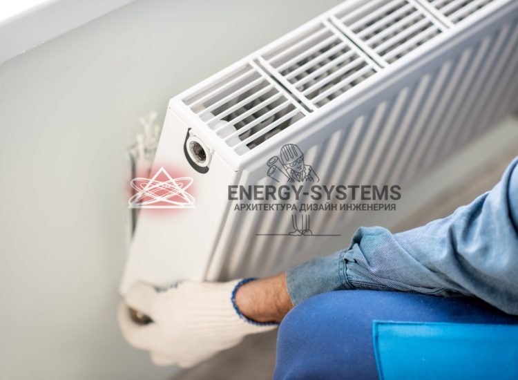 рабочий устанавливает радиатор отопления на стену