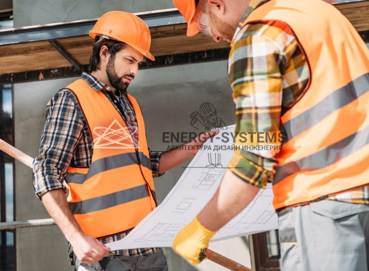 работники рассматривают проект на строительной площадке